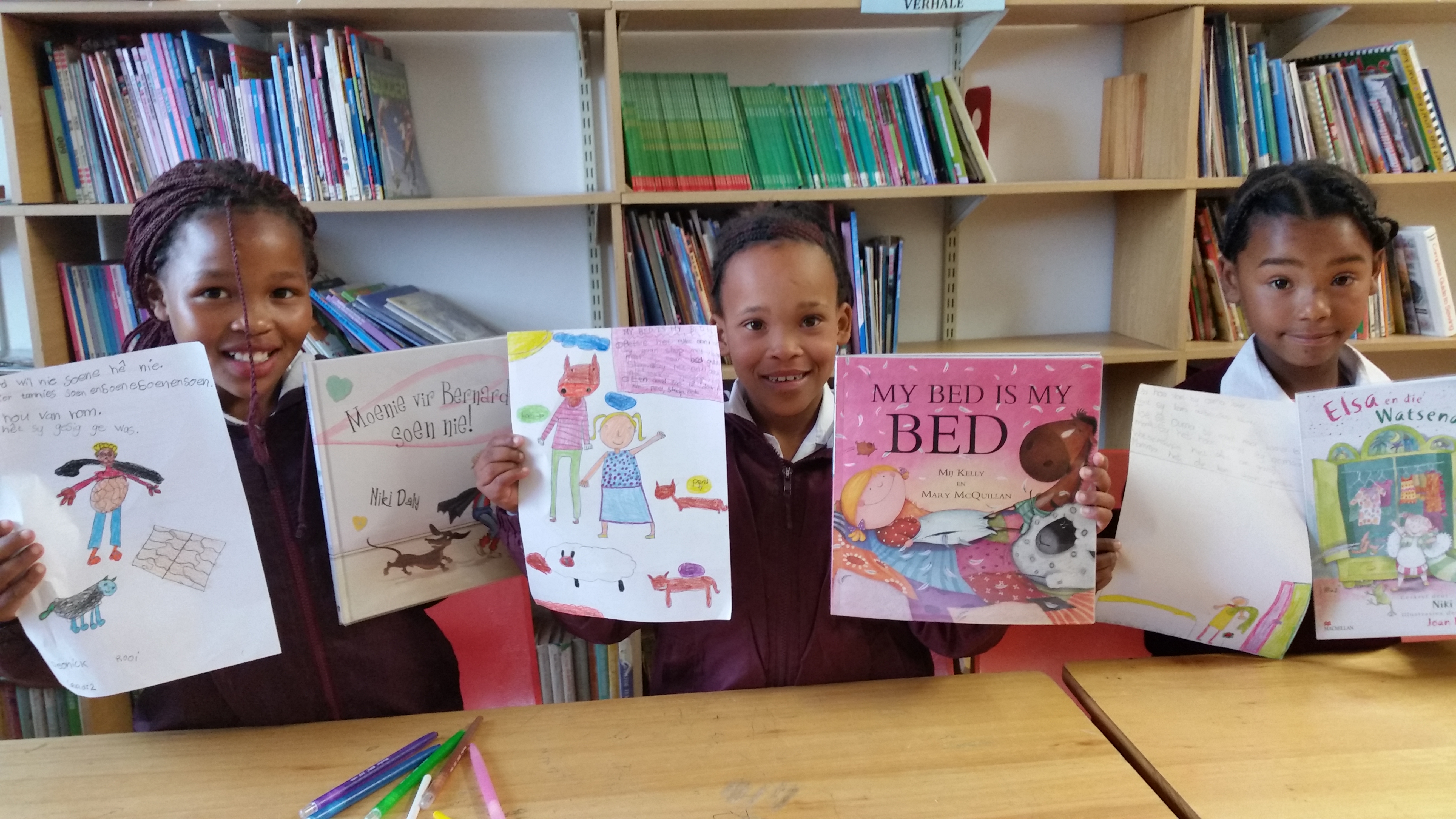 Grade 2s and a Grade 3 from George Frederick Primêr hold their favourite books and their own drawings, with independent writing, about the stories.